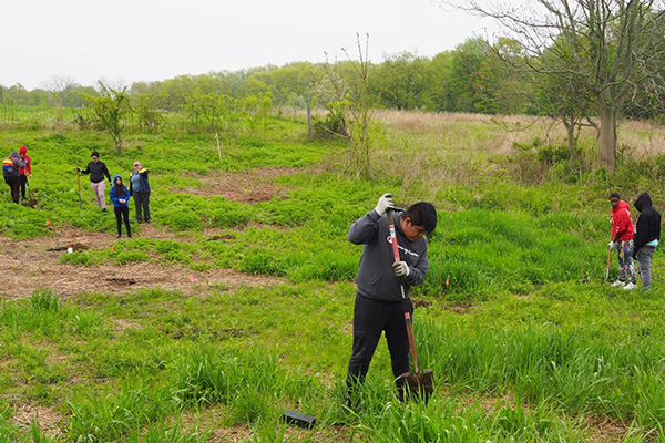 Digging holes. Ossining High School students with shovels in hand, digging holes for a riparian tree planting.