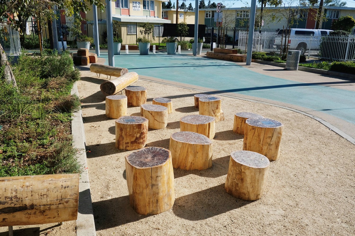 Bradley Green Plaza Alley with wooden benches and stools. A pastel-colored cul-de-sac with wooden benches and stools beside the street.