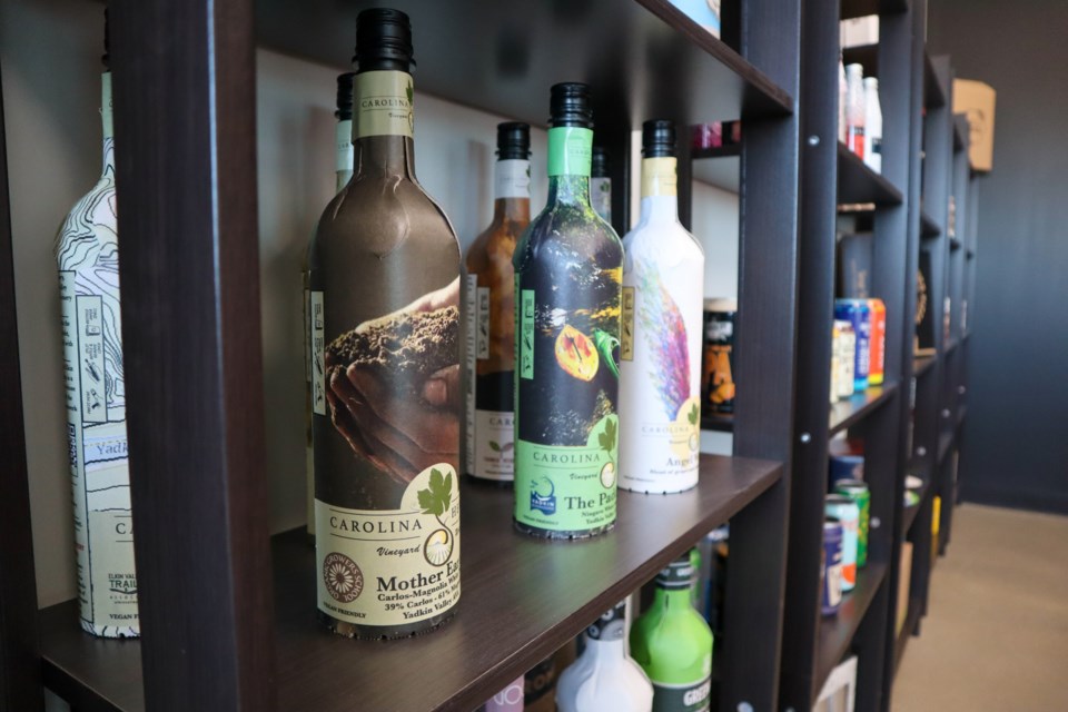 A photo of paper bottles with many different colorful labels on display shelves.