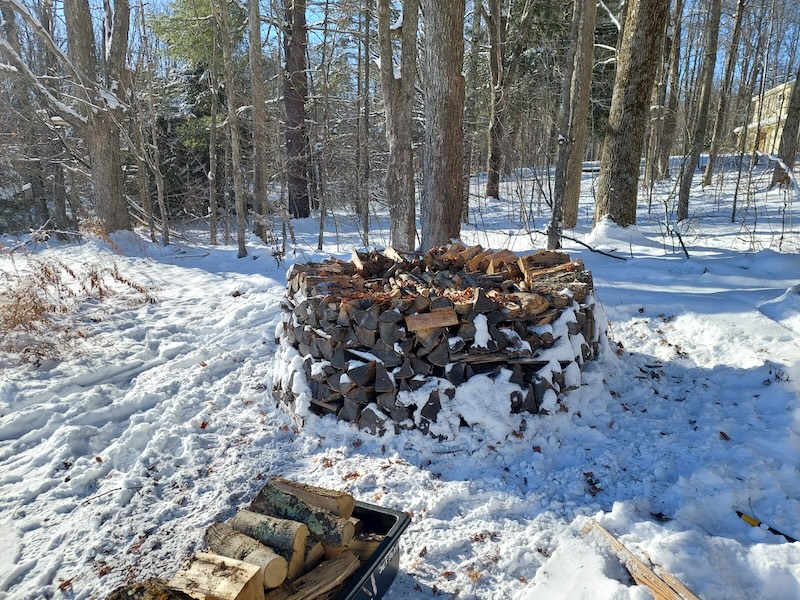 Jet sled Load #5 with the holz hausen in the background. The wood pile is a squat cylinder shape at this point. 